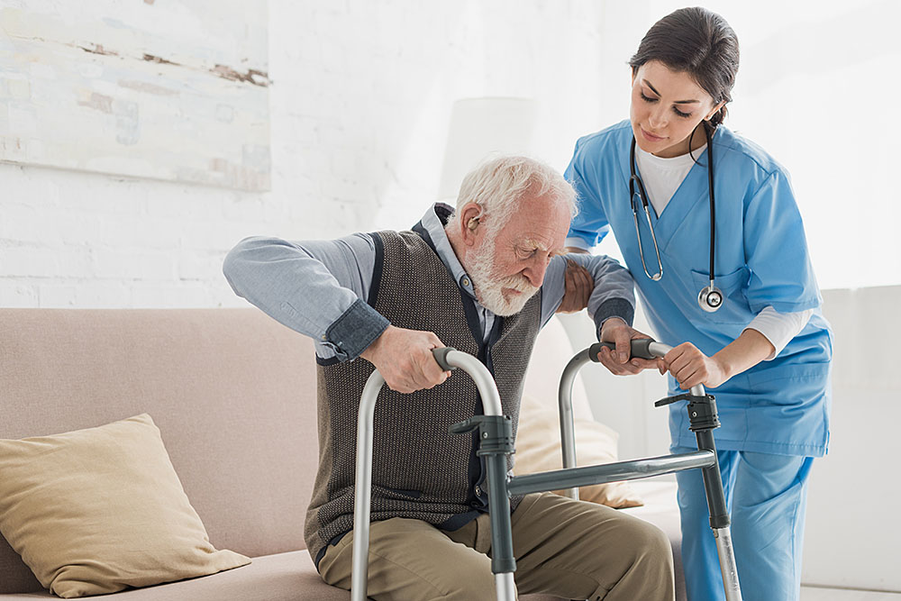 Doctor helping to retired man, getting up from sofa